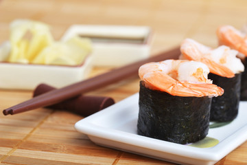 dish with fresh sushi rolls on bamboo napkin background