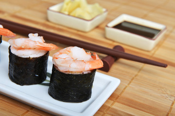 dish with fresh sushi rolls on bamboo napkin background