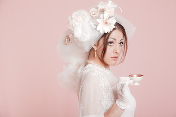 Retro romantic bride in white wedding dress drinking tea. Decora