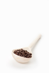 wooden spoon with coffee beans, isolated on white
