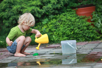White little barefoot girl playing with water © endostock