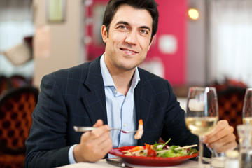 Handsome man eating at the restaurant