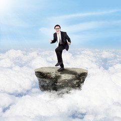 Happy businessman above clouds