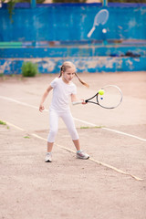 Adorable little child playing tennis