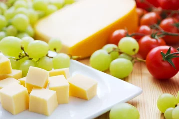 Selbstklebende Fototapete Vorspeise Käse mit Weintrauben und Tomaten