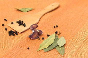 Pepper, garlic, bay leaf and wooden shovel.
