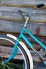 Fototapeta na wymiar Old bike stands near the wooden wall