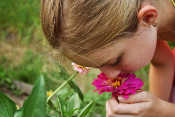 Obraz na płótnie Canvas Girl smelling a flower