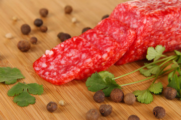 Tasty salami on wooden board close-up