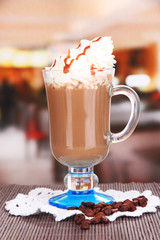 Layered coffee in glass on table on bright background