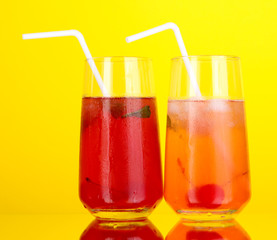 Two cherry cocktails with ice on yellow background.Keyword
