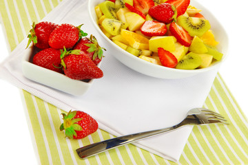 Useful fruit salad of fresh fruits and berries in bowl isolated