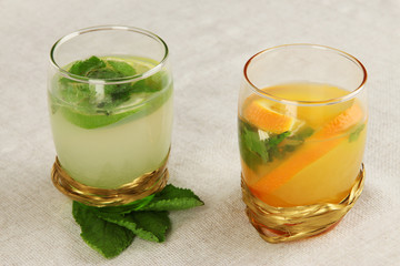 Lemonade in glasses on fabric background close-up