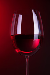 Glass of wine on bright red background