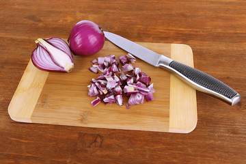 Cutting purple onion on wooden background