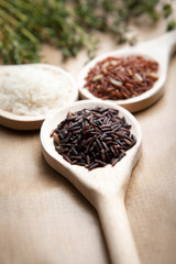 Red and white rice on wooden spoons
