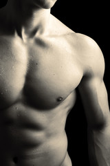 Man with naked muscled torso against black background