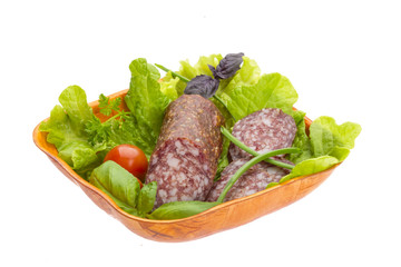 Ripe salami with salad, basil, onion and tomato