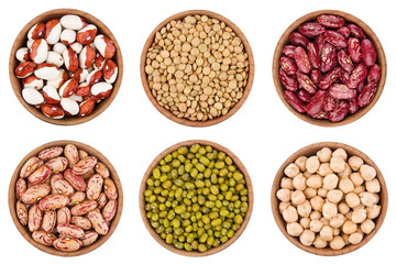Assortment of legumes in wooden bowls isolated on white