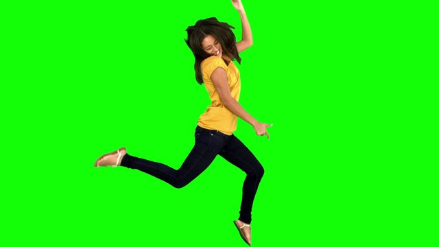 Cheerful woman jumping with legs and arms raised
