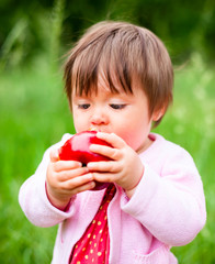 little girl eats an apple