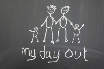 Blackboard with a child's drawing of a happy family day out.