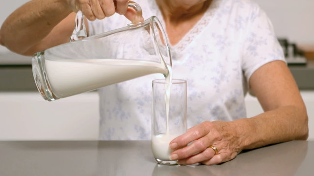 Woman pouring glass of milk