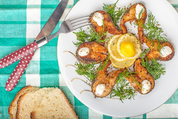 Сhopped pieces of fried fish on a tablecloth