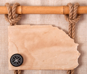 Compass, knot and old paper on the background of old cloth.