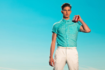 Retro fifties summer fashion man in blue shirt listens to portab