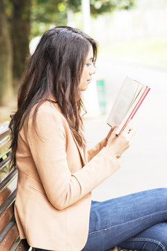 Woman reading book in the park.