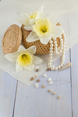 box with pearls, seashells and flowers on light-blue table