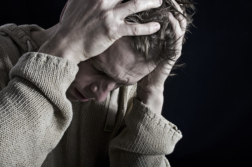 Depressed man closeup black background