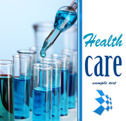 Laboratory pipette with drop of color liquid over glass test