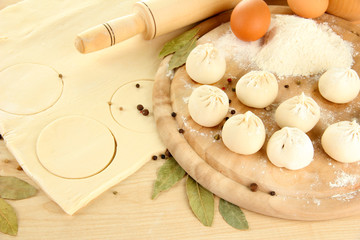 Raw dumplings and dough, on wooden table