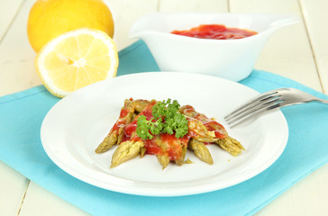 Asparagus on plate, on wooden background
