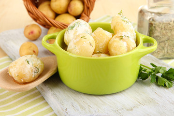 Tender young potatoes with sour cream and herbs in pan