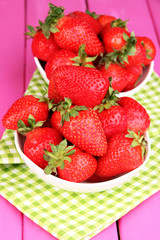Fototapeta na wymiar Fresh strawberry in bowl on pink wooden background
