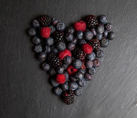 Heart of red fruit on black slate..