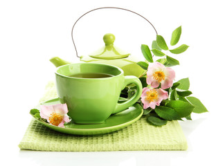 Cup and teapot of herbal tea with hip rose flowers, isolated