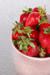 Strawberries in bowl on metal background
