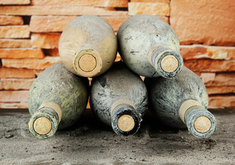 Old bottles of wine, on bricks background