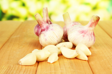 Fresh garlic on wooden table, on bright background
