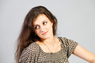 Brunette girl`s portret isolated on gray background.