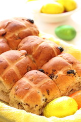 Hot cross buns in basket with easter eggs