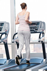 Woman at gym exercising. Run on machine