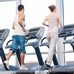 Fototapeta na wymiar Woman and man at the gym exercising.