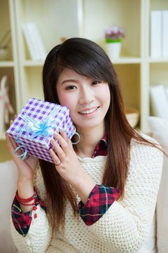 smiling young asian woman with a gift box