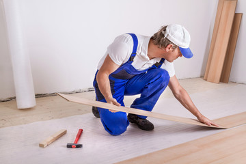 Male Worker laminate flooring.