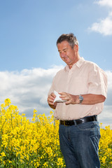 Man with hay fever on blooming rapeseed field